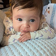 Brinley-Anne is registered to the contest to win money with this photo: baby, blanket, blue_eyes, child, close_up, cute, expression, face, floral, hand, indoors, infant, patterned_clothing, person, portrait, resting, skin, sleeve, soft_light, young_child