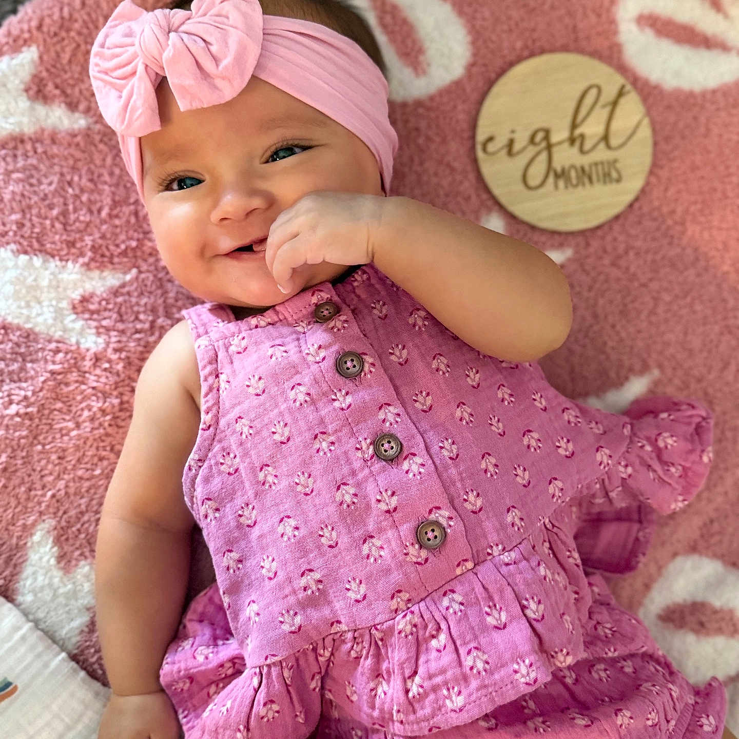 Ally joined the competition — help win amazing prizes! baby, blanket, bow, button, child, clothing, cute, face, hand, happy, headband, infant, lying_down, milestone, pattern, pink, portrait, smile, soft_texture, wooden_plaque