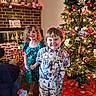 boy, celebration, child, christmas_tree, clothing, decorations, family, festive, fireplace, floor, girl, happy, holiday, home, indoor, lights, ornaments, presents, smile, toy