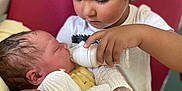 Diego Et Melyo participe au concours pour gagner de l'argent avec cette photo : child, baby, feeding, bottle, newborn, toddler, care, love, family, indoor, caring, holding, cute, infant, clothing, yellow, white, portrait, closeup, tender