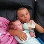 Diego Et Melyo participe au concours pour gagner de l'argent avec cette photo : child, baby, feeding, bottle, couch, leather, blanket, indoor, family, care, holding, sitting, young, infant, clothing, person, tender, home, love, comfort