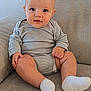 Idriss participe au concours pour gagner de l'argent avec cette photo : baby, infant, child, couch, socks, onesie, striped_clothing, drool, face, eyes, hands, legs, skin, seated, indoors, comfortable, cute, soft_furniture, portrait, smiling