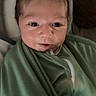 Rowan is registered to the contest to win money with this photo: baby, blanket, child, closeup, cute, expression, face, green, hair, indoors, infant, mohaawk, newborn, person, portrait, skin, smile, soft, wrapped, young