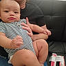 Destin joined the competition — help win amazing prizes! baby, black_couch, casual_clothing, child, closeup, curious, furniture, hand, home, indoor, infant, lap, medicine_boxes, person, relaxed, serious, sitting, skin, striped_onesie, support