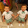 Donte joined the competition — help win amazing prizes! child, toddler, holding_hands, matching_outfits, white_shirt, green_bowtie, green_shorts, white_shoes, indoor, tile_floor, couch, clothing, person, smiling, expression, walking, home, furniture, fan, curtains