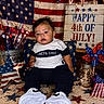 toddler, child, baby, american_flag, patriotic, 4th_of_july, independence_day, carpet, star_pattern, pinwheel, decorations, sign, sneakers, clothing, face, indoor, celebration, jar, lights, chair