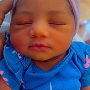 Riley is registered to the contest to win money with this photo: baby, newborn, sleeping, infant, cap, blue_clothing, pink_flower, hand, closeup, soft_light, peaceful, cute, portrait, child, skin, small_hand, resting, cozy, warm_tone, gentle