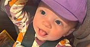 Zoey joined the competition — help win amazing prizes! toddler, child, car_seat, purple_cap, giraffe_embroidery, hand, playful, tongue_out, straps, seatbelt, patterned_clothing, smiling, indoor, cute, baby, person, closeup, happy, seat, casual
