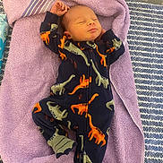 Louis joined the competition — help win amazing prizes! baby, newborn, sleeping, onesie, dinosaur, purple_towel, bed, blanket, infant, child, cute, cozy, resting, soft, comfortable, clothing, pattern, footed_pajamas, indoors, portrait