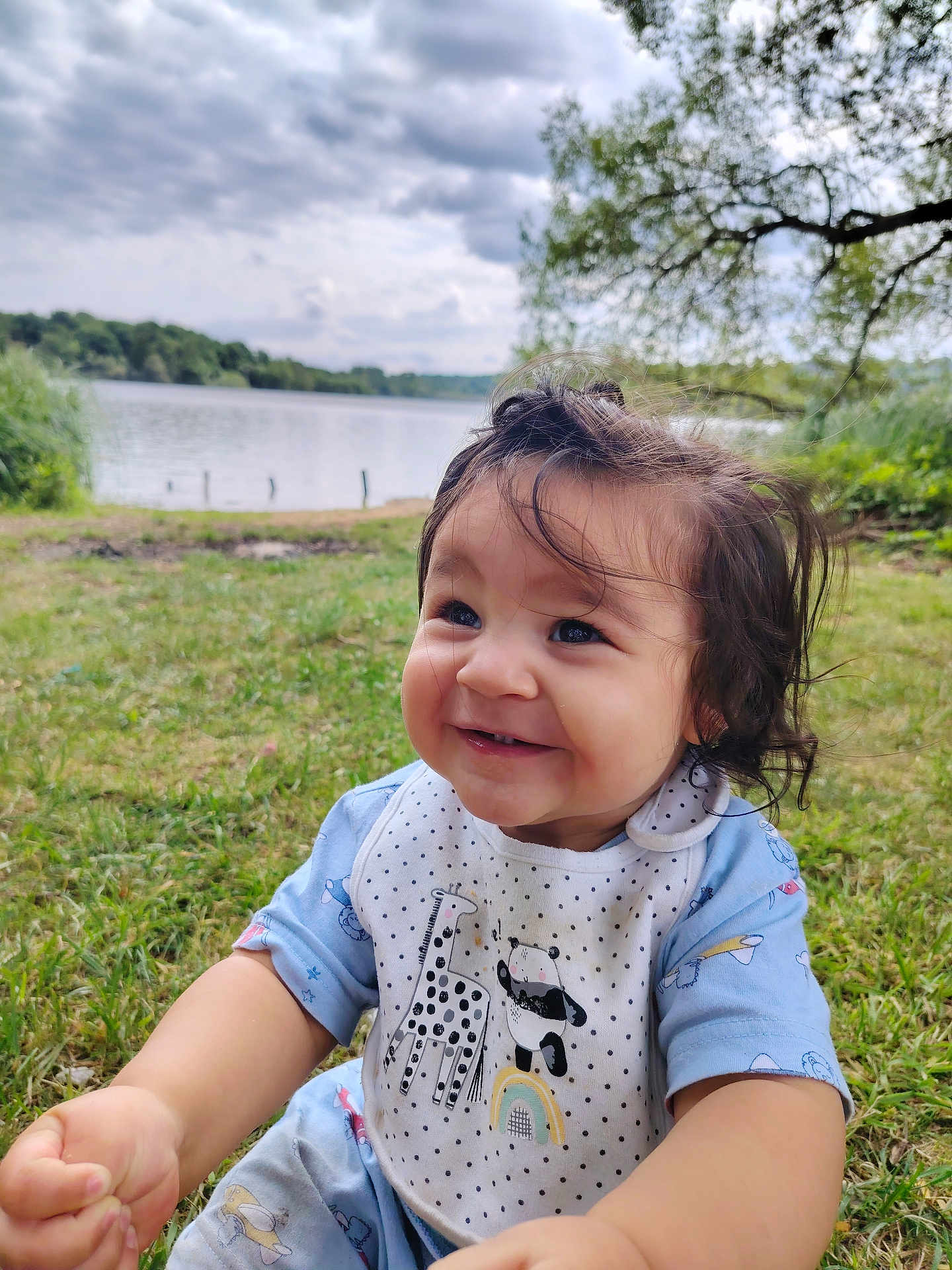 Angelo participe au concours pour gagner de l'argent avec cette photo : toddler, child, smiling, grass, lake, cloudy_sky, bib, giraffe, panda, outdoor, nature, greenery, happy, portrait, baby_clothes, cute, young_child, daylight, trees, water