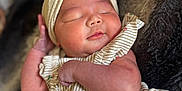 Kimberley is registered to the contest to win money with this photo: baby, sleeping, headband, bow, striped_clothing, floral_pattern, newborn, infant, soft_texture, blanket, cute, peaceful, resting, portrait, closeup, skin, hand, face, indoors, cozy