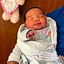 Kimberley is registered to the contest to win money with this photo: newborn, baby, blanket, wrapped, sleeping, infant, person, adult_arm, plush_toy, teddy_bear, heart_shaped_tag, baby_girl, soft_texture, blue_clothing, peaceful, indoors, portrait, cute, child, resting