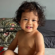 Jedidiah joined the competition — help win amazing prizes! toddler, child, curly_hair, smile, tongue, indoor, cushion, pattern, bare_chest, skin, face, eyes, nose, mouth, person, baby, sitting, cute, happy, young_child