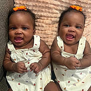 Denver And Desirae joined the competition — help win amazing prizes! baby, twins, infant, smiling, cute, orange_bow, white_outfit, ladybug_print, blanket, couch, indoor, portrait, child, happy, sitting, cute_expression, toddler, skin, face, hands