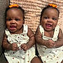 baby, twins, infant, smiling, cute, orange_bow, white_outfit, ladybug_print, blanket, couch, indoor, portrait, child, happy, sitting, cute_expression, toddler, skin, face, hands