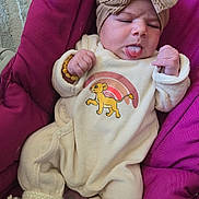 Alya participe au concours pour gagner de l'argent avec cette photo : baby, infant, newborn, bow_headband, tongue_out, onesie, lion_graphic, pink_seat, knitted_booties, bracelet, cute, funny_face, portrait, hands, carpet, cozy, fabric, clothing, head, person