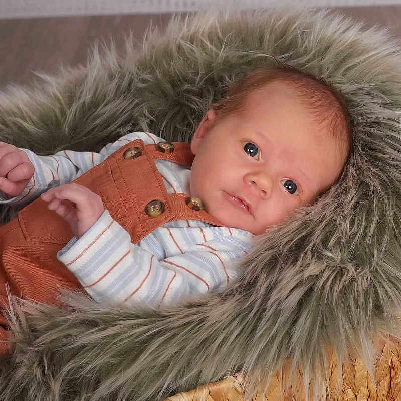 Myles is registered to the contest to win money with this photo: baby, blanket, clothing, coat, face, happy, head, hood, jacket, newborn, person, photography, portrait, smile