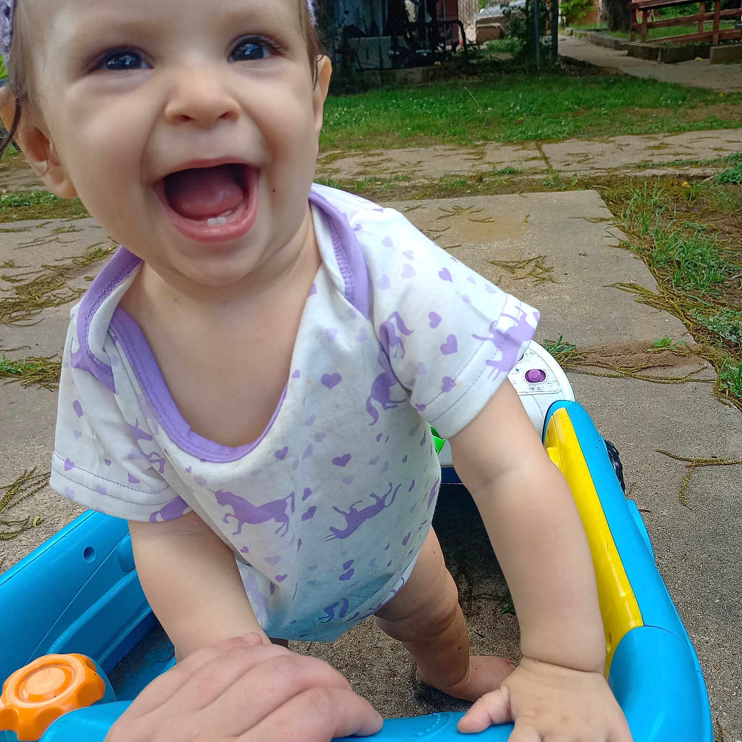 Emmalynn joined the competition — help win amazing prizes! baby, child, smiling, toy, walker, outdoor, hand, grass, concrete, tree, greenery, play, happy, person, clothing, headband, cute, young, support, nature