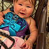 baby, child, stroller, purple_outfit, blue_flowers, bow, plush_toy, brush, pacifier, happy, smiling, cute, rosy_cheeks, indoor, person, infant, seated, toy, hand, face