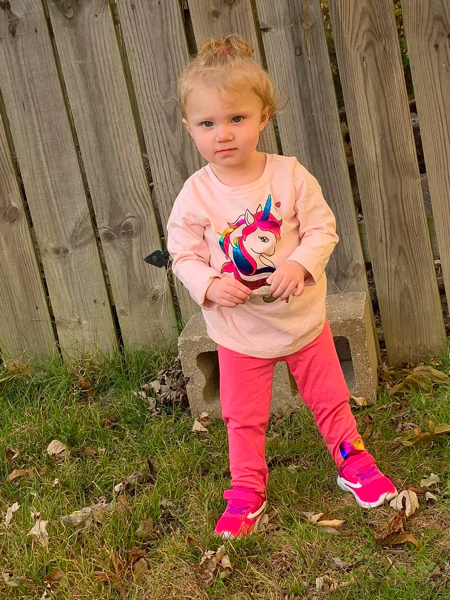 Lillian is registered to the contest to win money with this photo: baby_toddler_clothing, boot, child, foot, fun, grass, happy, human_leg, knee, leaf, leisure, magenta, people_in_nature, person, plant, sitting, sleeve, t_shirt, thigh, toddler