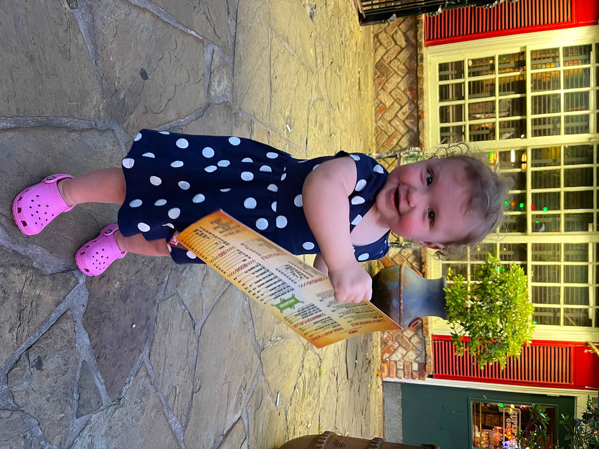 Lilyann is registered to the contest to win money with this photo: baby, baby_toddler_clothing, building, child, city, dress, fun, happy, house, human_leg, joy, leisure, pattern, person, plant, play, sitting, thigh, toddler, tree