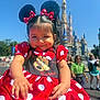 Ayla joined the competition — help win amazing prizes! child, toddler, minnie_mouse, costume, red_dress, polka_dots, mouse_ears, headband, smile, outdoor, theme_park, castle, sunny, people, background, daylight, portrait, fun, happy, vacation