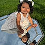 toddler, child, girl, dress, flower_crown, mirror, reflection, grass, outdoor, sunny, smiling, cute, portrait, playing, nature, happy, curly_hair, white_dress, greenery, daytime