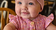 Hadley joined the competition — help win amazing prizes! baby, girl, child, headband, pink, dress, smile, blue_eyes, indoor, blurred_background, cute, happy, seated, wooden_chair, portrait, infant, clothing, fashion, person, toddler