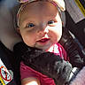 baby, infant, child, car_seat, headband, floral, smiling, face, blue_eyes, sunlight, blanket, pink_shirt, clothing, seatbelt, safety, portrait, cute, happy, closeup, indoors