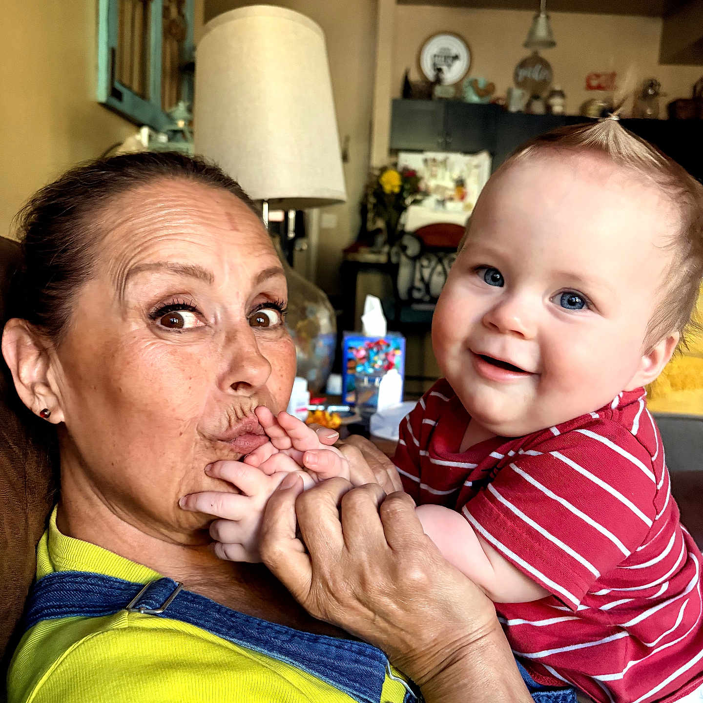 Mickey joined the competition — help win amazing prizes! baby, adult, smile, happy, face, hand, hair, indoor, lamp, furniture, home, person, clothing, red_shirt, yellow_shirt, overalls, skin, portrait, interaction, family