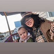 Mateo joined the competition — help win amazing prizes! baby, child, clothing, costume, curly_hair, daylight, family, glasses, happy, hat, house, outdoor, person, porch, portrait, railing, smile, street, window, woman