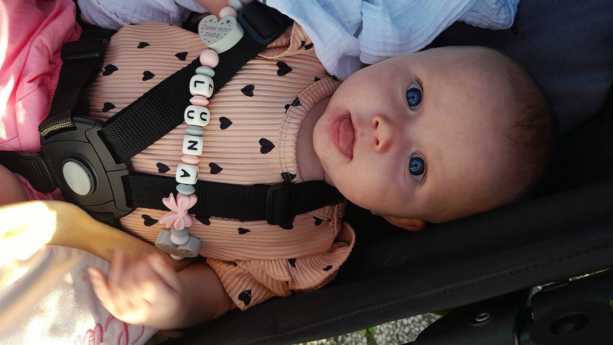 Luna participe au concours pour gagner de l'argent avec cette photo : baby, baby_products, baby_toddler_clothing, button, cheek, child, collar, eyebrow, eyelash, lip, nail, nose, pattern, person, sitting, skin, sleeve, thumb, toddler, wood