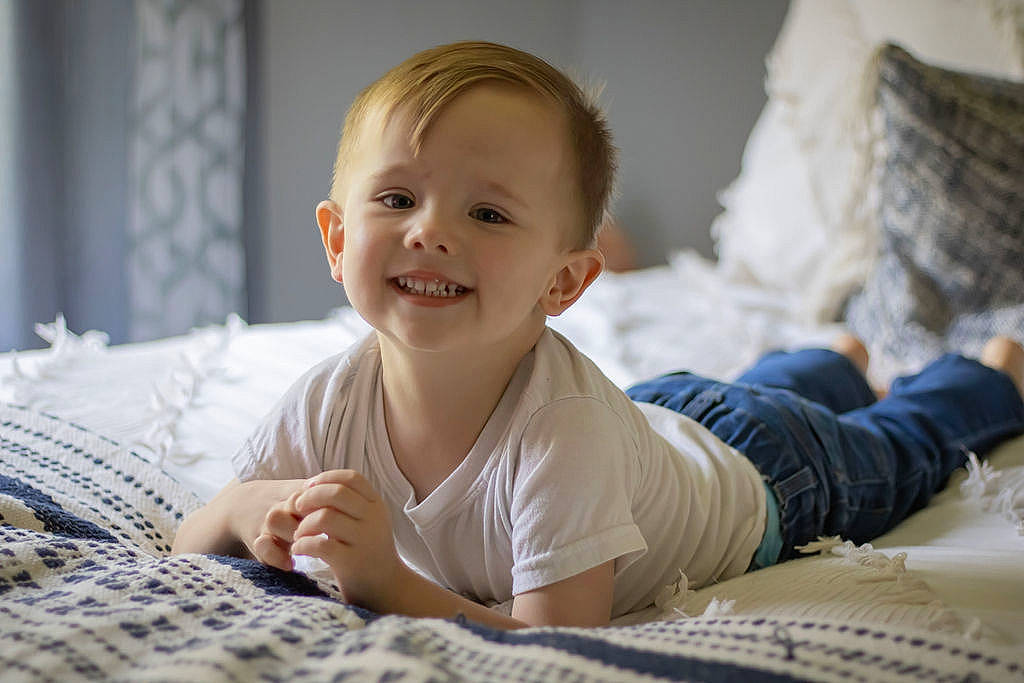 Easton is registered to the contest to win money with this photo: baby, baby_toddler_clothing, cheek, child, comfort, dress, face, facial_expression, floor, flooring, happy, head, joy, linens, nose, person, skin, sleeve, smile, toddler