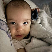 Alynn is registered to the contest to win money with this photo: baby, blanket, closeup, face, infant, sleeping_area, soft_texture, cushion, cozy, indoors, child, portrait, warm, comfort, young, skin, expression, resting, wrapped, cute