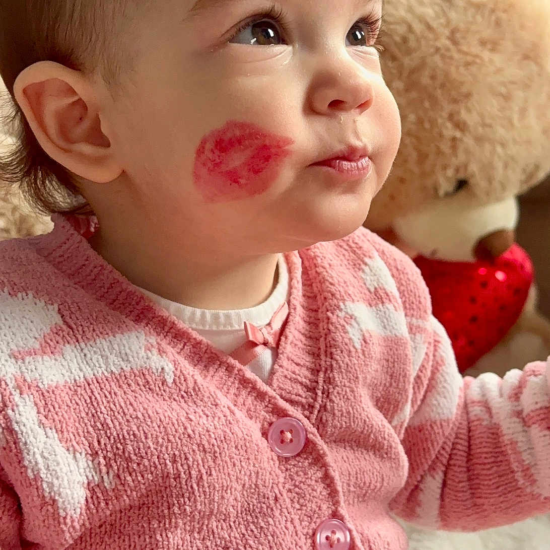 Alynn joined the competition — help win amazing prizes! adorable, baby, buttoned_clothing, child, childhood, closeup, cute, face, hair_bow, indoor, lipstick_mark, looking_away, pink_cardigan, portrait, seated, soft_texture, stuffed_animal, teddy_bear, toddler, warm_lighting
