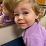 blonde_hair, casual, child, closeup, curious, curly_hair, cute, earring, expression, face, happy, indoor, mirror, person, portrait, purple_shirt, reflection, smile, toddler, young_child