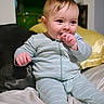 Niko is registered to the contest to win money with this photo: baby, child, pajamas, striped_clothing, indoor, bed, blanket, pillow, face, hand, sitting, infant, cute, portrait, soft_lighting, person, young_child, sleepwear, comfort, cozy