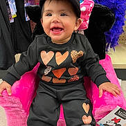 Kailany is registered to the contest to win money with this photo: accessories, baby, bodypart, cap, chair, clothing, costume, face, finger, furniture, hand, happy, hat, head, pants, person, photography, portrait, purple, smile