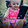 toddler, child, smiling, outdoor, phone, colorful_clothing, pink_top, skirt, chair, camo_pattern, happy, face, messy_face, grass, summer, person, sitting, technology, cute, portrait