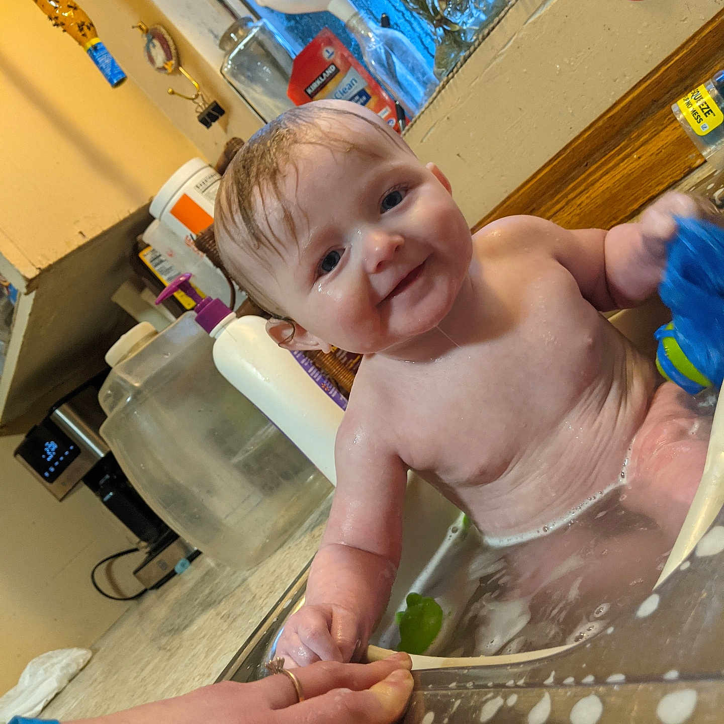 Aladar is registered to the contest to win money with this photo: baby, bath, sink, water, toy, hand, kitchen, window, bottle, countertop, smile, wet, child, person, indoor, play, clean, happy, skin, foam