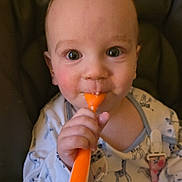 Austin is registered to the contest to win money with this photo: baby, child, spoon, high_chair, onesie, giraffe_pattern, face, hand, eating, curious, indoor, closeup, infant, feeding, messy_face, seatbelt, cute, expression, person, young_child