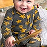 toddler, child, pajamas, stars, smiling, indoor, wooden_stick, toy, drum, happy, person, floor, playful, cute, baby, sitting, face, blonde_hair, carpet, cozy