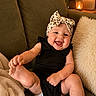 baby, smiling, headband, black_outfit, couch, green_couch, pillows, cozy, indoor, happy, child, infant, cute, foot, hand, cheerful, portrait, living_room, lamp, blanket