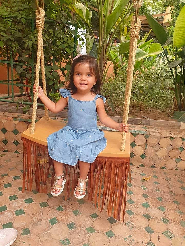 Mariya participe au concours pour gagner de l'argent avec cette photo : baby_toddler_clothing, child, dress, facial_expression, fun, grass, happy, human_body, human_leg, joy, leaf, leisure, people_in_nature, person, plant, sandal, sitting, skin, smile, toddler