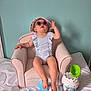 baby, child, armchair, polka_dot, hat, sunglasses, toys, boat, blanket, indoor, wall, furniture, colorful, cute, relaxed, person, pink, blue, green, playtime