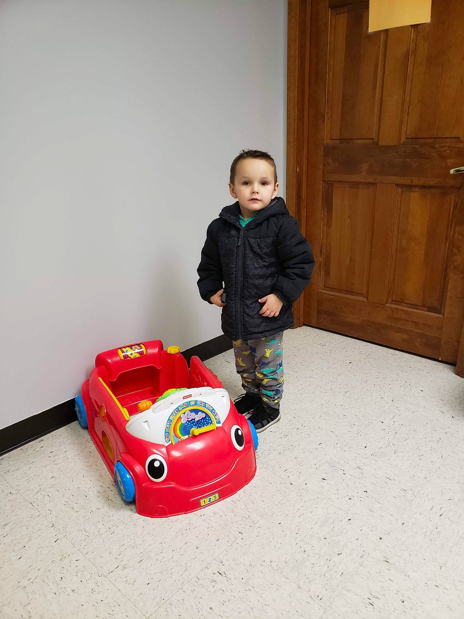 Abel James Klingsmith is registered to the contest to win money with this photo: automotive_design, baby_toys, car, child, floor, flooring, model_car, person, play, playset, radio_controlled_car, radio_controlled_toy, red, room, toddler, toy, toy_vehicle, vehicle
