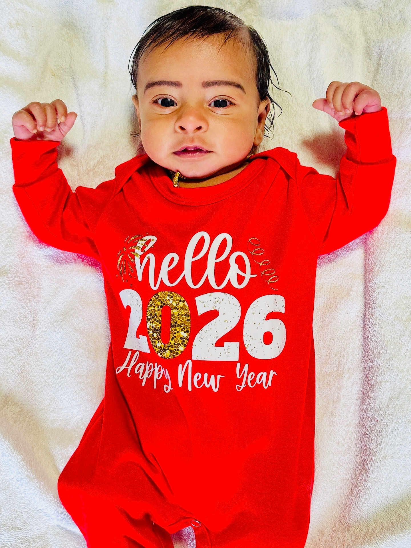 Vihaan joined the competition — help win amazing prizes! baby, infant, red_onesie, face, arms_raised, blanket, new_year, text_on_clothing, portrait, lying_down, cute, child, smiling, happy, indoors, skin, hair, eyes, person, celebration