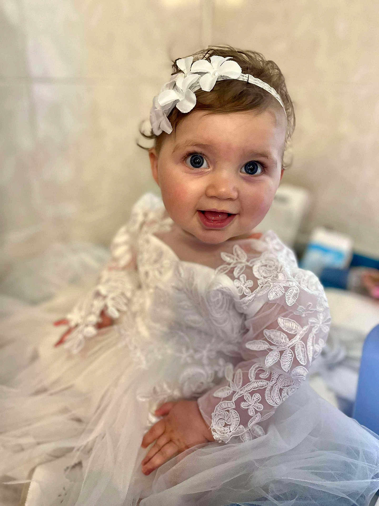 Adèle participe au concours pour gagner de l'argent avec cette photo : baby, child, smiling, dress, lace, headband, flower, white, cute, portrait, sitting, happy, indoor, soft_focus, infant, young_child, face, hand, eyes, clothing
