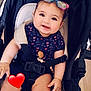 accessory, baby, baby_girl, blue_clothing, bracelet, child, cute, glasses, happy, heart_pattern, indoor, infant, person, pink_socks, playful, portrait, seatbelt, smiling, stroller, toy_clip