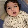 animal_print, baby, blanket, child, closeup, cozy, cute, expression, face, happy, indoors, infant, lying_down, onesie, portrait, sleepwear, smiling, soft, warm, young